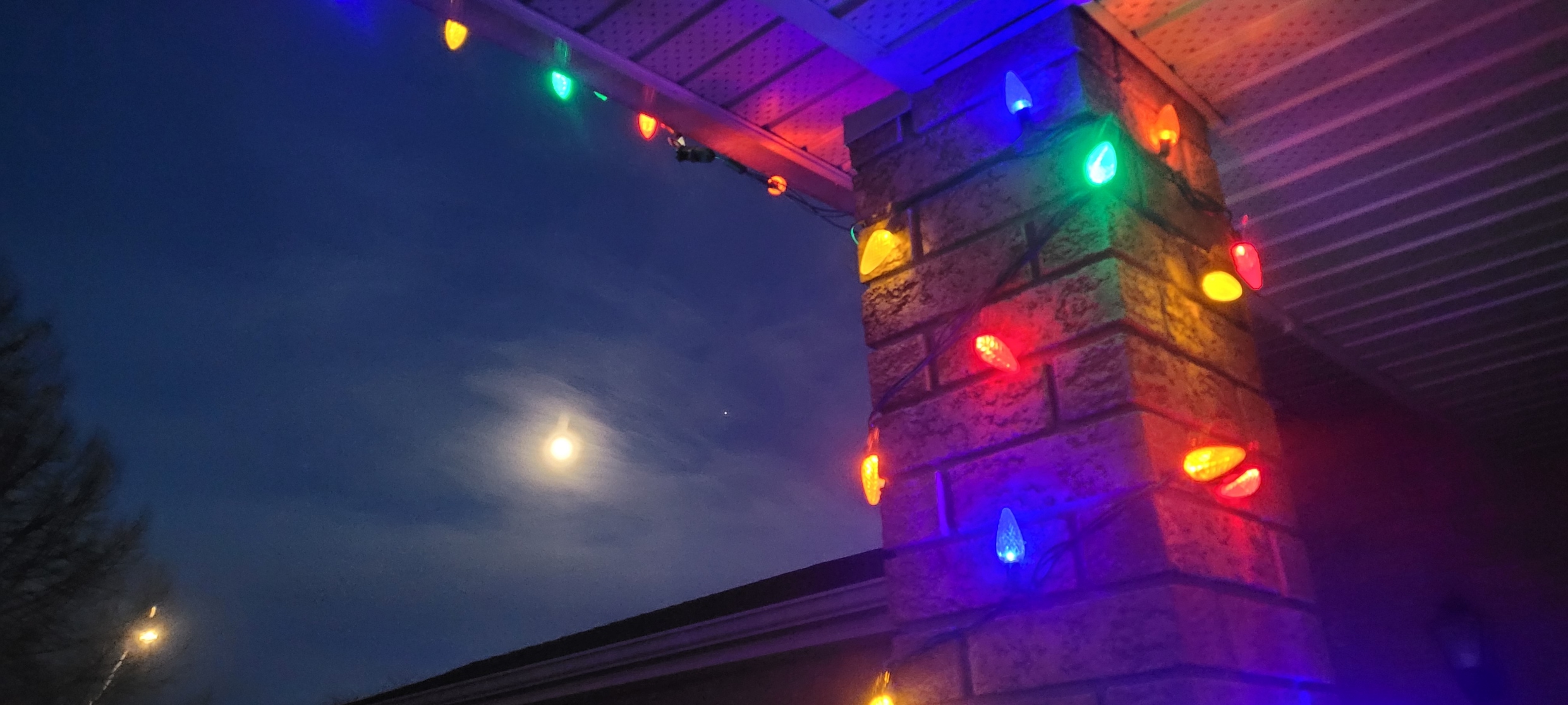Christmas lights strung along the eave of a house.